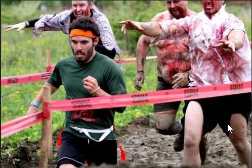 Un hombre corre adelante de una manada de Zombies